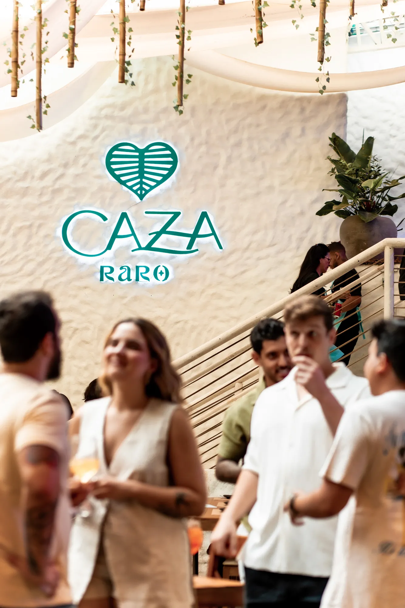 Amigos conversando frente al panel CAZA RARO · 29 de marzo de 2025