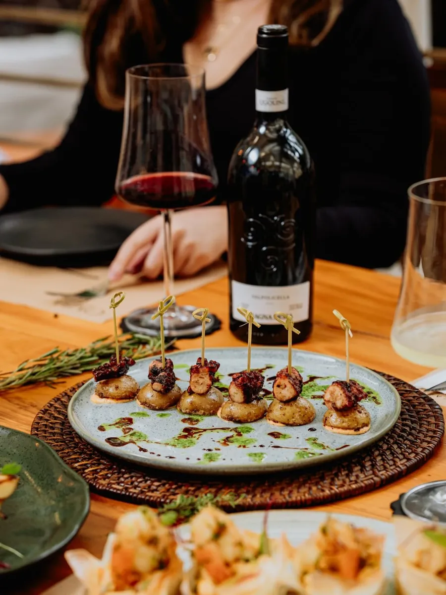Platos de autor y vino en una mesa de Caza Raro
